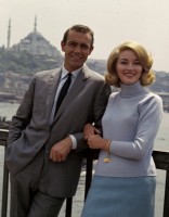 FROM RUSSIA WITH LOVE - James Bond (SEAN CONNERY) and Tatiana Romanova (DANIELA BIANCHI) stand together in front of a scenic background including the Hagia Sophia..jpg